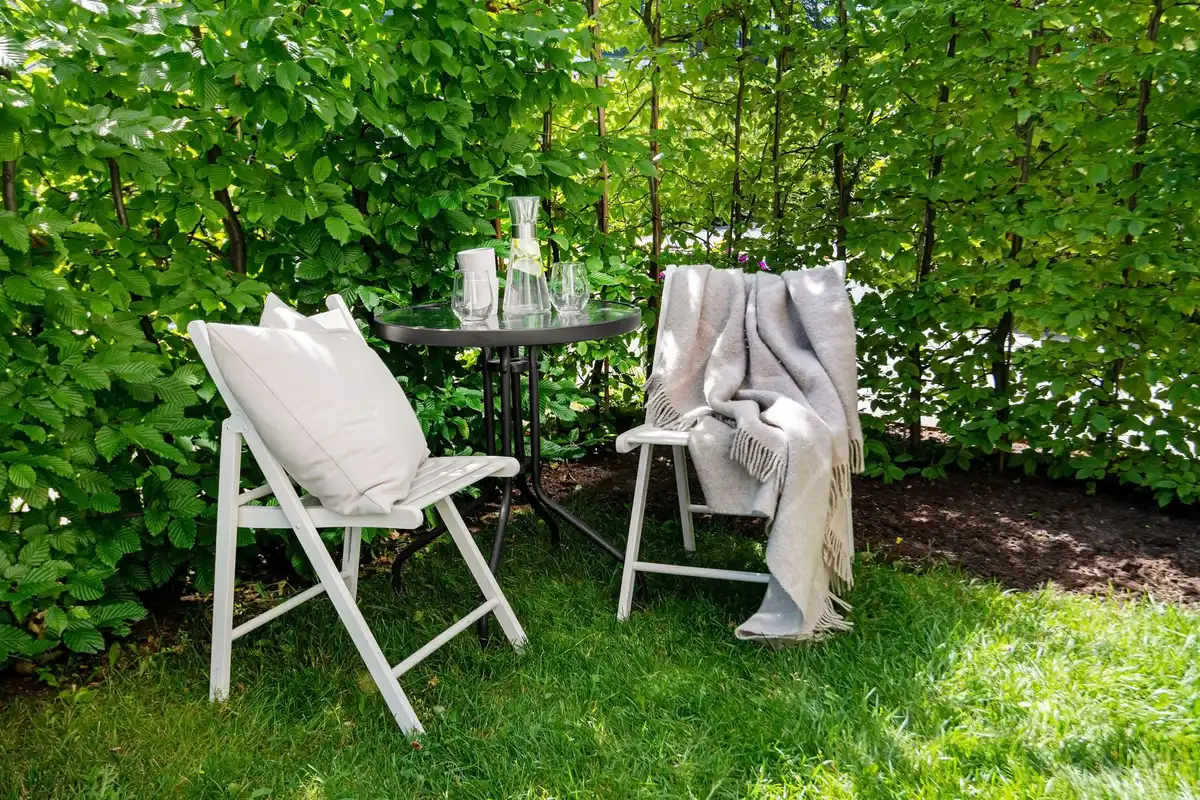 Petit jardin aménagé avec mobilier pliant et rangements verticaux pour optimiser l'espace