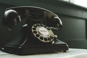 Personne contactant le service client par téléphone avec documents de commande à proximité