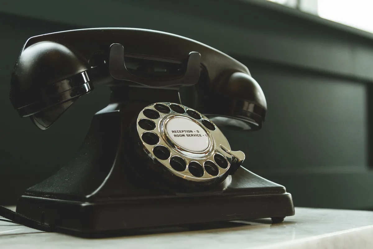 Personne contactant le service client par téléphone avec documents de commande à proximité