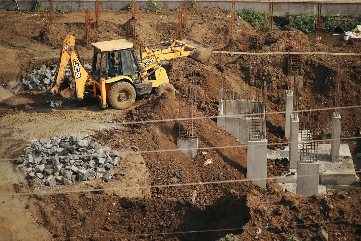 Préparation du sol et mise en place d'une fondation en béton pour fixer une serre
