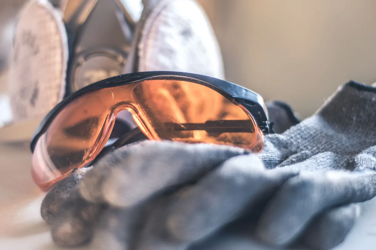 Opérateur portant gants, lunettes et protection auditive lors de l'utilisation d'une rainureuse