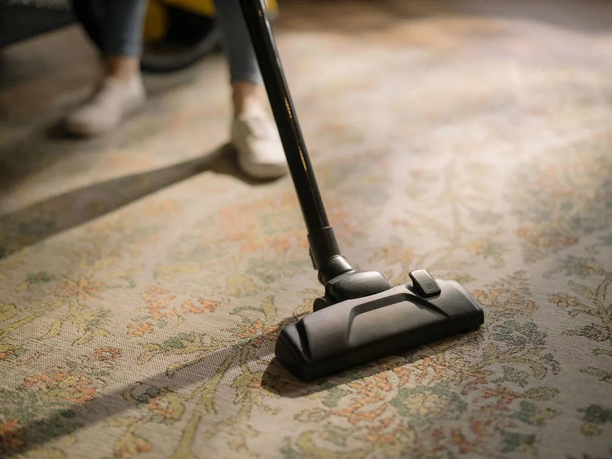 Aspirateur passé lentement sur un tapis pour éliminer poussière et débris incrustés