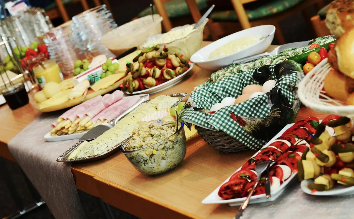 Buffet bien organisé sur une table avec supports de hauteurs variées dans une salle lumineuse