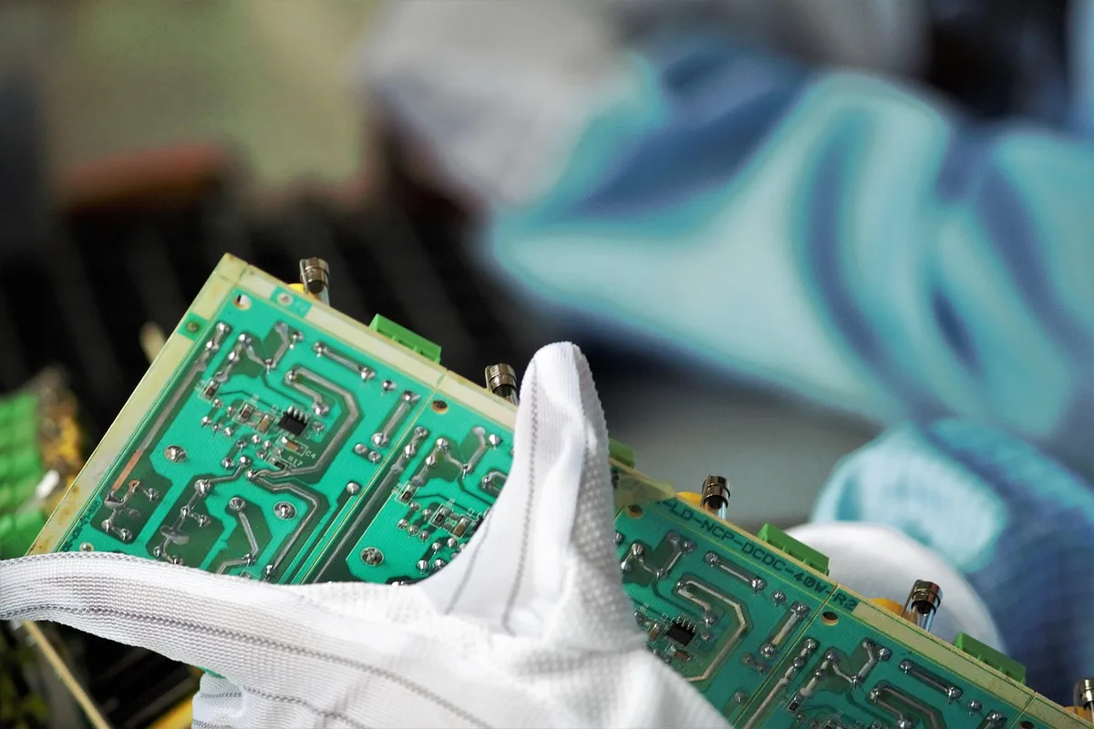 Opérateur vérifiant des dimensions avec des instruments de mesure dans un atelier éclairé